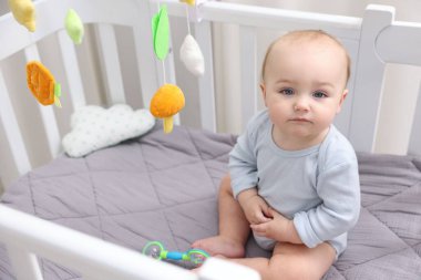 Evinde bebek karyolası olan küçük şirin bir bebek.