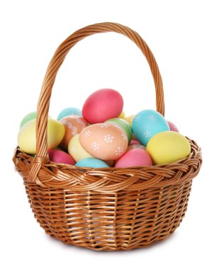 Hasır sepetteki boyanmış Paskalya yumurtaları beyaza izole edilmiş.