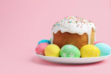 Nefis dekore edilmiş Paskalya pastası ve pembe arka planda yumurtalar. Metin için boşluk