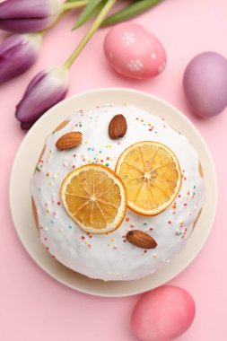 Güzel Paskalya pastası, pembe arka planda yumurtalar ve laleler, düzlük