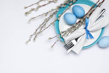 Paskalya kutlaması. Söğüt dalları ve beyaz arka planda boyanmış yumurtalarla bembeyaz masa ayarları. Metin için boşluk