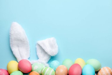 Mutlu Paskalyalar. Şirin tavşan kulakları ve açık mavi arka planda yumurtalar, düz bir şekilde yatıyordu. Metin için boşluk