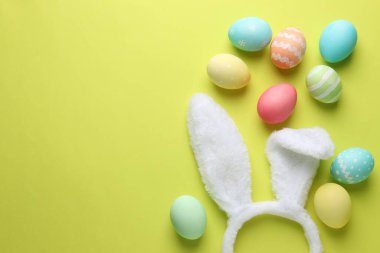 Mutlu Paskalyalar. Tatlı tavşan kulakları ve sarı arka planda boyanmış yumurtalar. Metin için boşluk