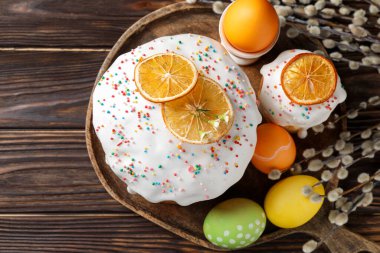 Güzel Paskalya pastaları, yumurtalar ve söğütler ahşap masada, düz yatıyordu.