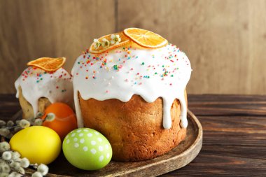 Güzel Paskalya pastaları, yumurtalar ve söğütler ahşap masada.