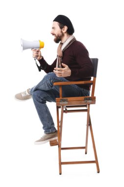 Kızgın film yönetmeni, beyaz arka planda sandalyede megafona bağırıyor.