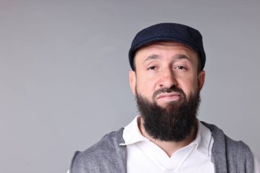 Açık gri arka planda bıyıklı ve sakallı bir adam. Metin için boşluk