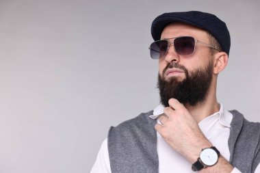 Açık gri arka planda bıyıklı ve sakallı bir adam. Metin için boşluk