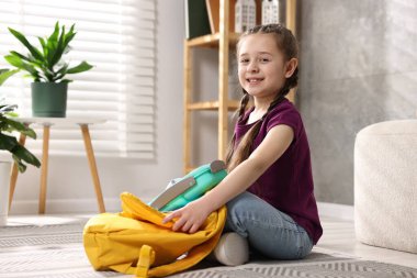 Okul için sırt çantasını toplayan bir kız. Metin için boşluk