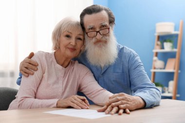 Ahşap masada son arzuları ve vasiyetnameleri imzalayan yaşlı çift.