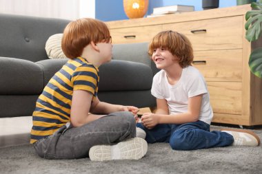 İki kardeş evde yerde birlikte vakit geçiriyorlar.