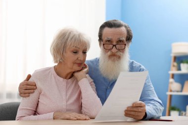 Ahşap masada son arzusu ve vasiyetnamesi olan yaşlı bir çift.