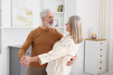 Güzel yaşlı çift evde dans ediyor.