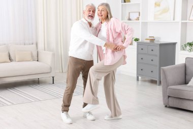 Güzel yaşlı çift evde dans ediyor.