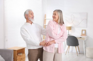 Güzel yaşlı çift evde dans ediyor.