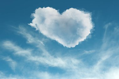 Mavi gökyüzünde sevimli yumuşak kalp şeklinde bulut