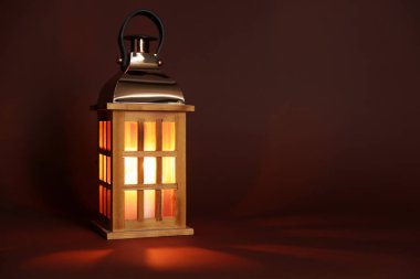 Kahverengi arka planda güzel bir Noel feneri, metin için boşluk