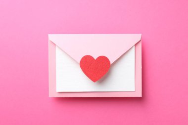 Tebrik kartı ve pembe arka planda dekoratif kalp ile zarf, üst görünüm