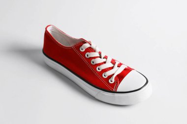 Beyaz arka planda şık bir kırmızı spor ayakkabı.