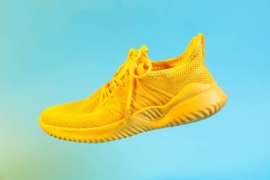 Açık mavi arkaplanda şık bir spor ayakkabı.