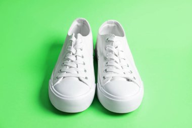 Yeşil arka planda şık bir çift spor ayakkabı, yakın plan.