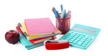 Ev ödevi. Renkli not defterleri, elma, hesap makinesi ve beyaz üzerine izole edilmiş farklı kırtasiye yığınları