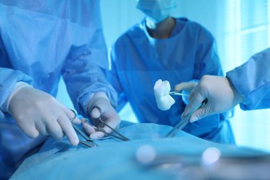 Tıbbi aletleri olan profesyonel cerrahlar ameliyathanede ameliyat yapıyorlar.