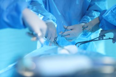 Tıbbi aletleri olan profesyonel cerrahlar ameliyathanede ameliyat yapıyorlar.