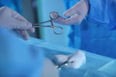 Tıbbi aletleri olan profesyonel cerrahlar ameliyathanede ameliyat yapıyorlar.