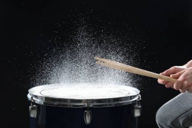 Siyah arkaplanda davul çalan bagetli adam, yakın plan