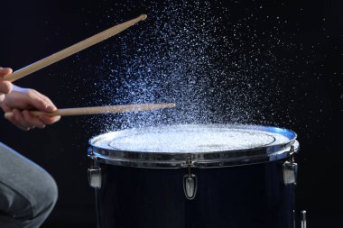 Siyah arkaplanda davul çalan bagetli adam, yakın plan