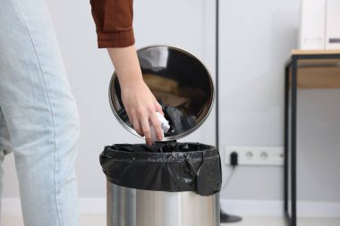 Kadın peçeteyi çöp kutusuna atıyor, yakın plan.