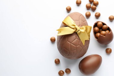Beyaz arka planda çikolatalı Paskalya yumurtaları ve şekerler. Metin için boşluk