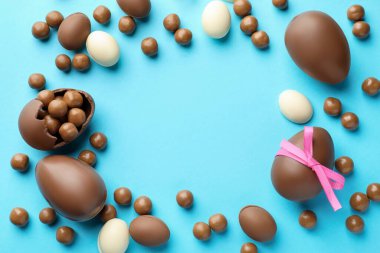 Açık mavi arkaplanlı çikolatalı Paskalya yumurtaları. Metin için boşluk
