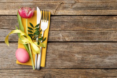 Paskalya sofrası. Lale ve ahşap arka planda boyalı yumurta ile güzel gümüş takımlar, üst manzara. Metin için boşluk