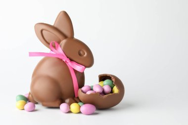 Çikolatalı Paskalya tavşanı ve beyaz arka planda şekerli yumurtalar. Metin için boşluk