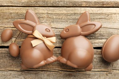 Çikolatalı Paskalya tavşanları ve yumurtalar ahşap masada, düz yatıyordu.