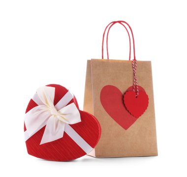 İçinde kalp şeklinde hediye paketi olan kağıt torba beyaza izole edilmiş. Sevgililer Günü