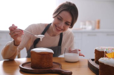Geleneksel Paskalya pastasını mutfakta jöleli dekore eden genç kadın, eline odaklan.