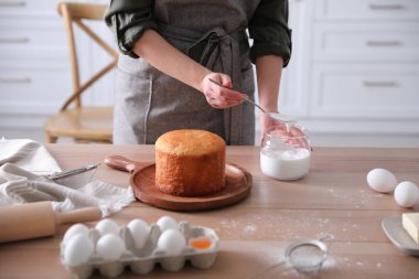 Geleneksel Paskalya pastasını mutfakta jöleli dekore eden genç bir kadın.