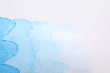 Beyaz kağıt üzerinde soyut mavi suluboya resim, üst görünüm. Metin için boşluk