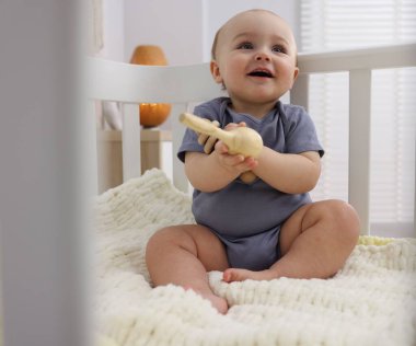 Evinde ahşap çıngıraklı şirin bir bebek.