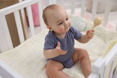 Evinde ahşap çıngıraklı şirin bir bebek.