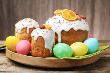 Nefis dekore edilmiş Paskalya pastaları ve yumurtalar ahşap masada, yakın plan.