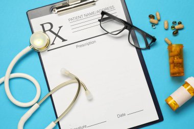 Açık mavi zemin üzerinde stetoskop ve pano ile düz konum