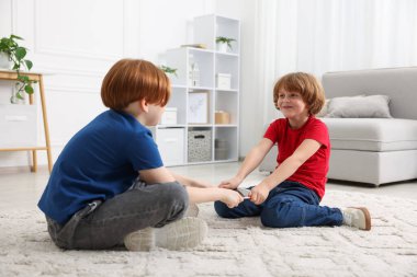 Evde tablet üzerinde kavga eden iki kardeş.