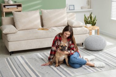Evdeki kanepenin yanında sevimli köpeği olan bir kadın.