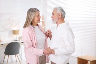 Güzel yaşlı çift evde dans ediyor.