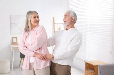 Güzel yaşlı çift evde dans ediyor.