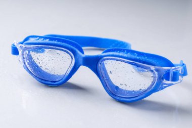 Işık yüzeyinde su damlaları olan yüzme gözlükleri, yakın çekim